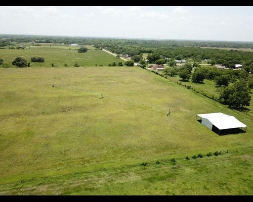 A large field with a white building in the middle of it